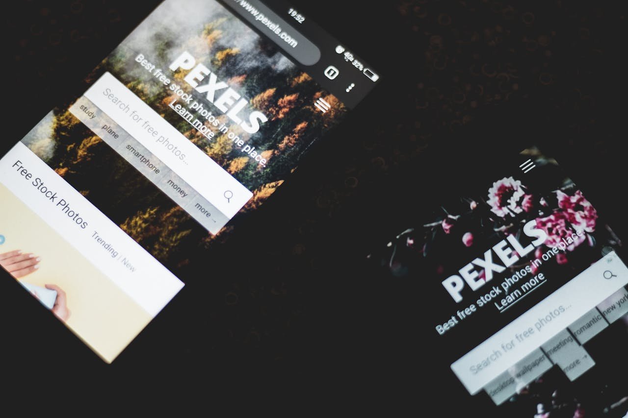 services-01 Close-up of smartphones displaying Pexels stock photo website, showcasing modern technology.