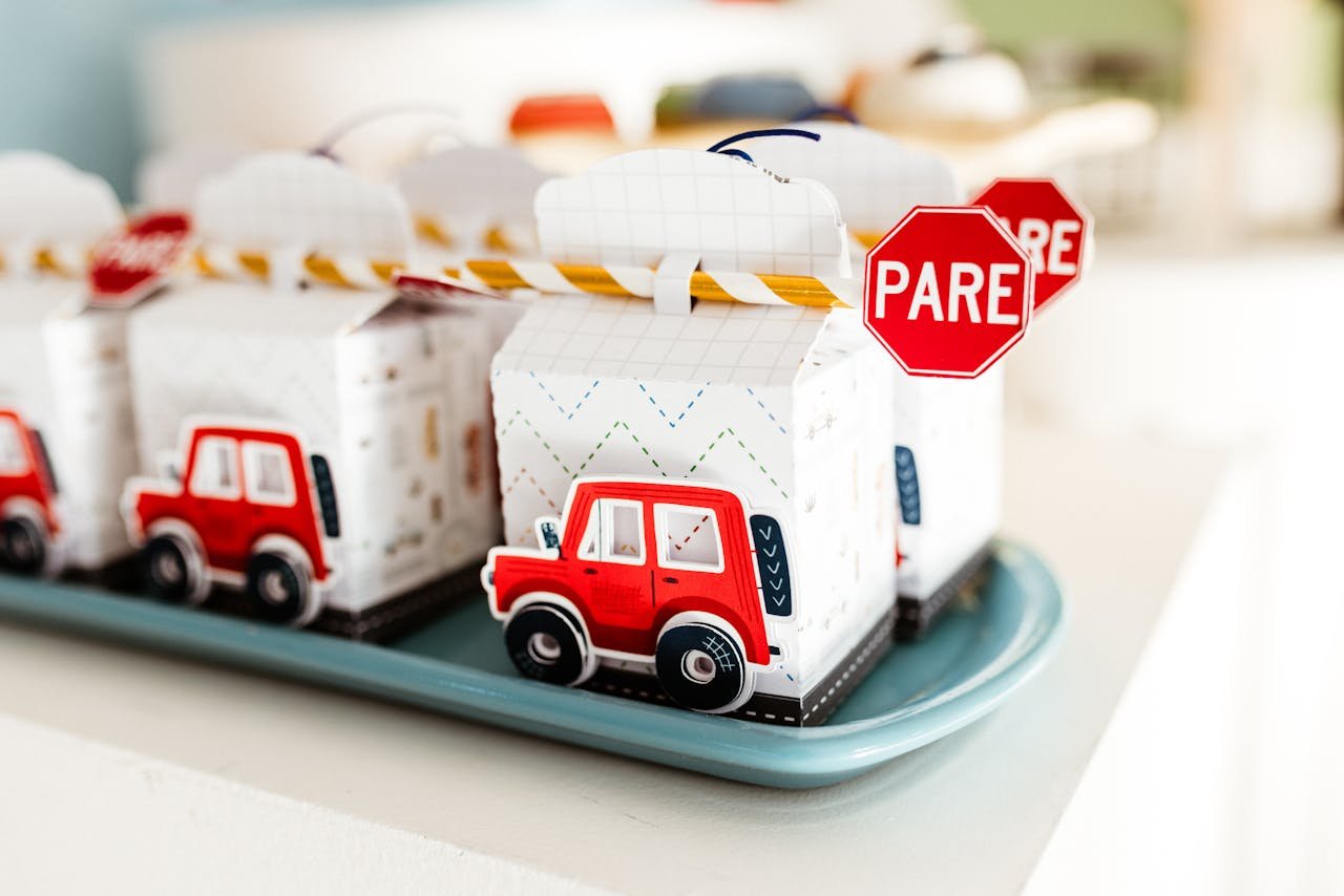 about-01 Brightly colored toy car gift boxes with 'Pare' stop signs, ideal for kids' parties.